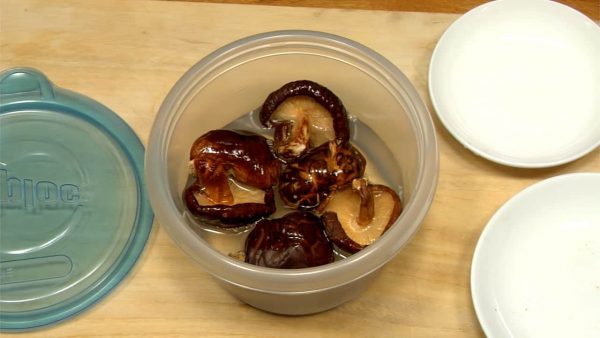Let’s make Shiitake Fukumeni by reducing the shiitake dashi stock. Put the pre-washed dried shitake mushrooms in a container and add water.