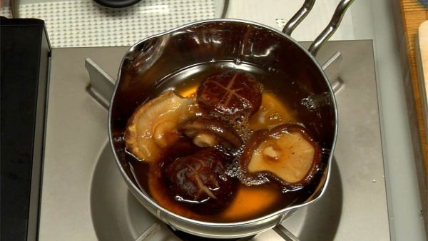 Put the shiitake into a small pot and pour in the liquid. Turn on the burner.