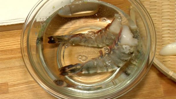 Let's prepare the prawns for tempura. Let the prawns thaw in water for about 20 minutes. Remove the shells but leave the tails attached.