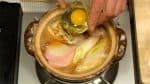 沸騰したら卵を容器に割り入れ、鍋に入れます。