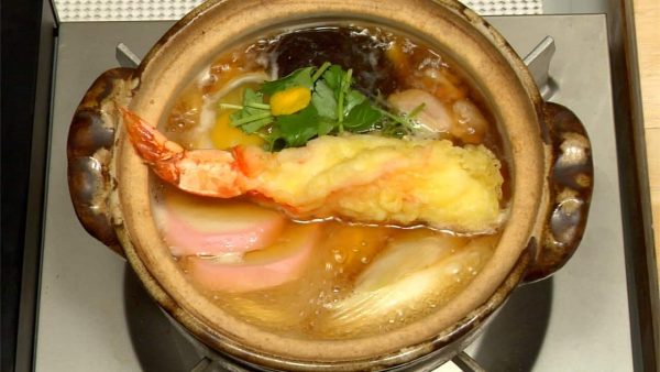 Finally, garnish with the mitsuba parsley and yuzu peel. Top with the prawn tempura.
