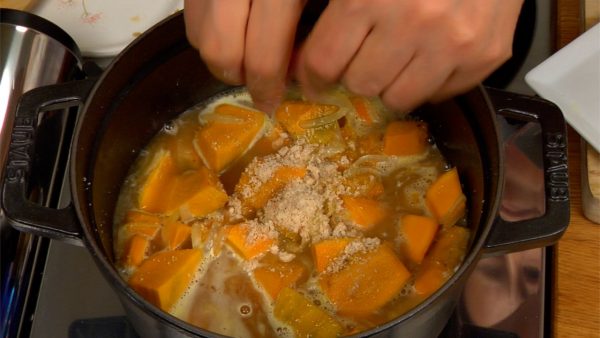 Add the water to the pot. Crumble the chicken bouillon cube into the mixture. Distribute it evenly among the vegetables with a paddle. Bring to a boil on high heat.