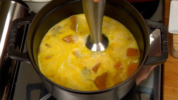 Ajoutez le lait dans la casserole. Avec un mixeur à main, mixez la courge jusqu'à ce qu'elle soit onctueuse et crémeuse. Une spatule ou un fouet électrique peut faire le même travail ou vous pouvez aussi écraser la courge à travers une passoire fine. 