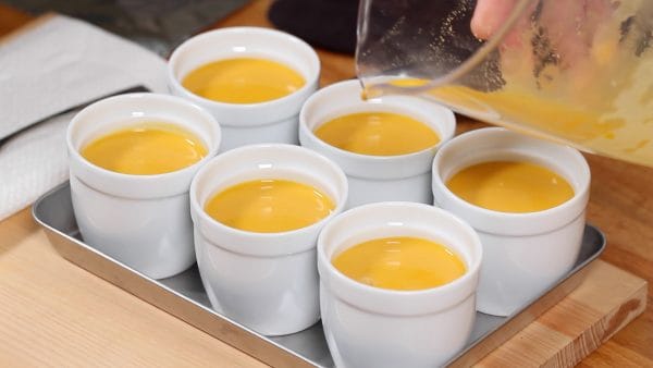 Let’s steam the pudding. Pour the egg mixture into 6 custard cups. Remove the foam on the surface with a spoon.