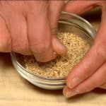 Bóp chặt hạt vừng trắng rang bằng các ngón tay của bạn để tăng hương vị.