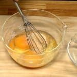 Préparez le tamagoyaki, omelette roulée japonaise. Cassez 2 œufs dans un bol. Ajoutez le sucre et le sel, et battez bien les œufs. 