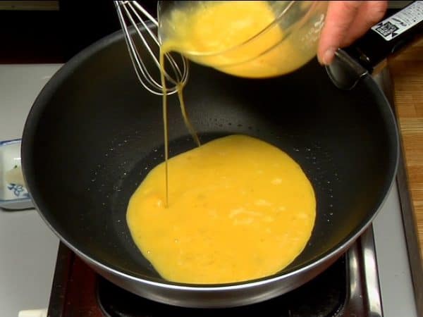 玉子焼きを作ります。フライパンに油をしき、温まったのを確認してから、まず半分くらい流し入れます。