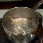 Faites cuire les crevettes. Ajoutez le sel dans la casserole d'eau bouillante. Placez les crevettes avec le pic en bambou dans l'eau bouillante. 