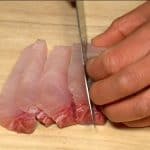 Cắt lát kampachi, cá cam Nhật Bản lớn hơn thành các miếng 1cm (0,4 inch).