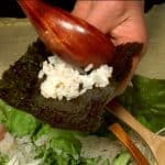 Here is an example of how to eat Temaki Sushi. Place a small amount of the sushi rice on a sheet of toasted nori.