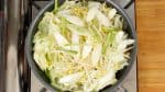 Add the cabbage leaves, onion, soy sprouts, long green onion and the firm stalk part of the garlic chives.