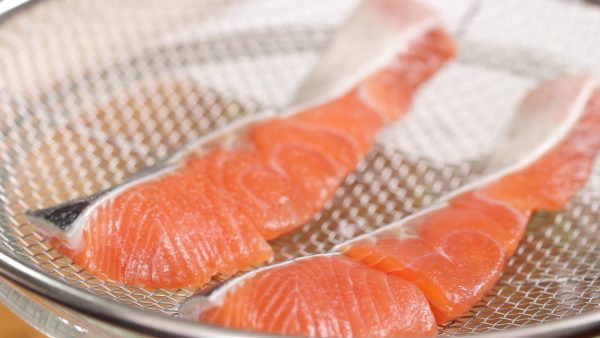 Place the salmon onto a mesh strainer and let it sit for about 15 minutes. This will help it to absorb the seasoning and also remove the unwanted smell.