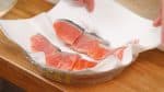 Bilas filet salmon dengan air dan gosok bersih sisiknya. Letakkan salmon diatas tisu dapur dan keringkan.