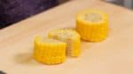 Potong jagung yang sudah direbus menjadi ukuran 3cm (1.2"). Kemudian, belah 2 setiap bagian.