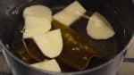 Pour the dashi stock into a pot along with the kombu seaweed. Add the potato. And turn on the burner.