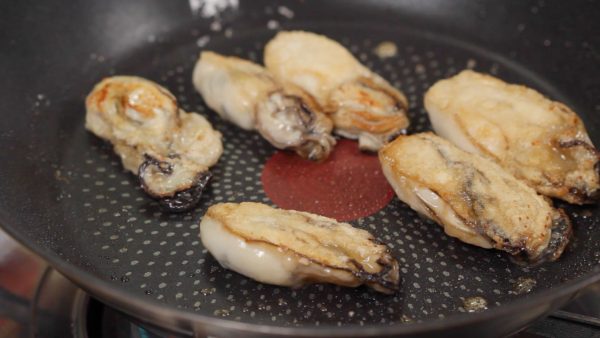 Brown the oysters and flip them over. When both sides are golden brown, remove the oysters and set aside.