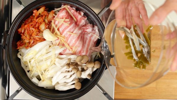 Ensuite, versez-y le bouillon dashi. Faire mijoter le kombu et les niboshi va faire un excellent bouillon. Ils sont parfaitement comestibles, mais vous pouvez les retirer à la fin si vous voulez. Ensuite, ajoutez le sake et allumez le feu.