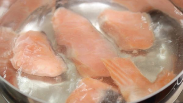 Place the salmon into a pot of boiling water.