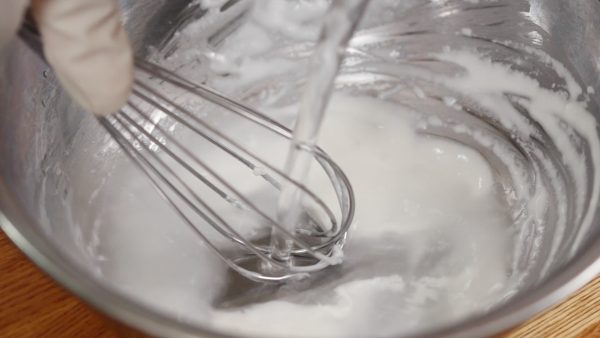 Let’s make the batter for the wrapper. Add a small amount of water to the shiratamako or mochiko, sweet rice flour. Mix thoroughly. When the clumps of flour have disappeared, add the rest of the water. Mix again.