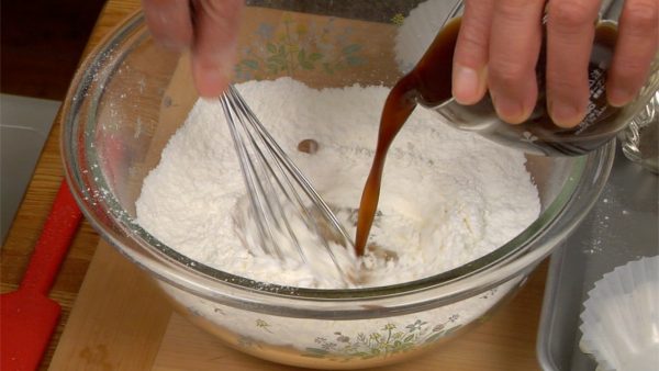 Tuang larutan brown sugar ke bagian tengah tepung sambil diaduk menggunakan balloon whisk (pengaduk berbentuk balon). Campurkan tepung secara bertahap dari tengah ke pinggir. Ini untuk membantu menghindari gumpalan tepung kering.