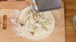 然後，將大蔥和蘑菇片放置在面皮上。您也可以使用香菇、或鴻喜菇代替舞茸。