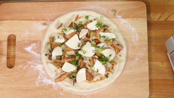 Arrange the sliced mozzarella cheese. You can also add your favorite type of pizza cheese to taste. Sprinkle on the chopped spring onion leaves.