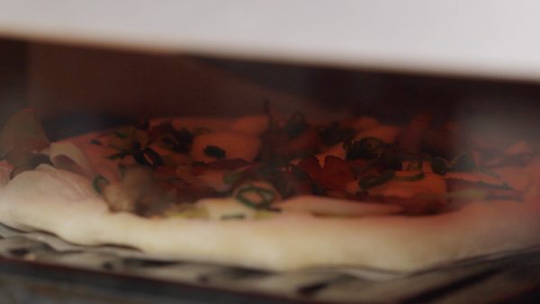Be sure to preheat the oven to 250 °C (480 °F) while stretching the dough. Place the pizza into the oven and bake at 250 °C (480 °F) for about 4 to 5 minutes. Using an upturned baking sheet will make the pizza closer to the heat source.