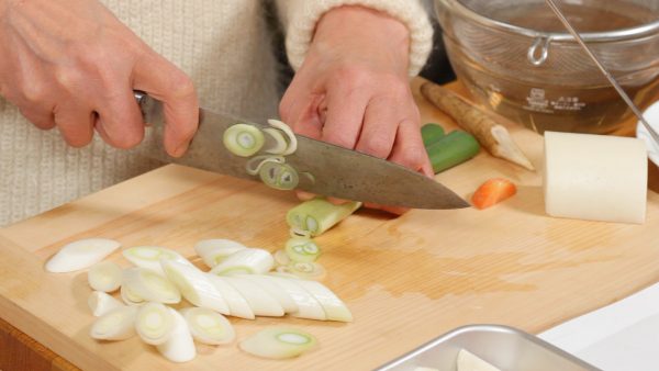 Coupez la partie blanche du poireau en tranches diagonales d'1 cm (0.4 inch). Coupez la partie verte en tranches fines. 