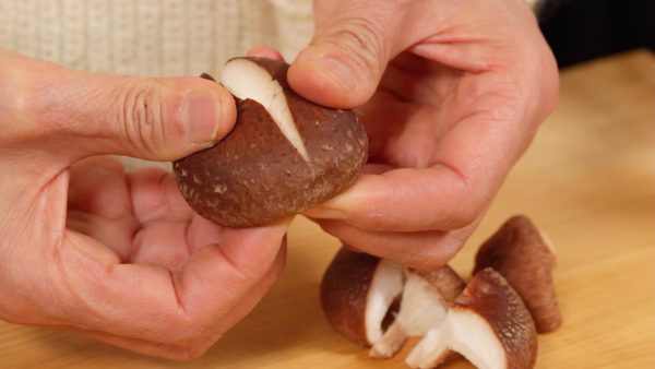 Remove the stems of the shiitake mushrooms and cut a shallow “X” into the top. Tear each cap into 4 pieces.