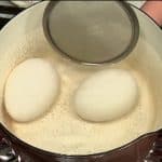 Chúng tôi sẽ làm trứng luộc lòng đào. Đảm bảo để trứng chuyển sang nhiệt độ phòng trước khi sử dụng. Để trứng vào nồi nước và bật bếp. Lật nhẹ những quả trứng đến khi nước bắt đầu sôi.