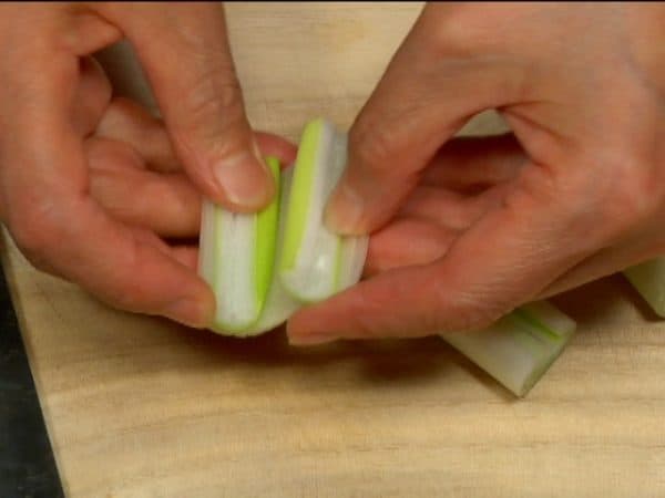 Let's prepare the toppings. Cut the white part of the long green onion into 4cm (1.6") lengths. Make a cut along the side of each, removing the cores.
