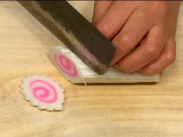 Slice the narutomaki, a type of steamed fish cake, into thin slices.