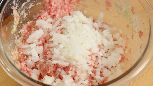 Add the chopped onion. Roughly mix and blend the onion with the meat.