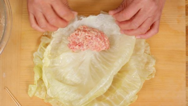You will be using 2 leaves, both a small size and a large size, to make each cabbage roll. Place the smaller leaf on top of the large cabbage leaf, and spoon one-eighth of the meat mixture onto it.