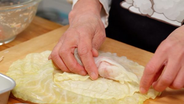 Wrap the meat with the small leaf. The leaves may have some slits, but using 2 sheets of cabbage will help to wrap the meat tightly and evenly.