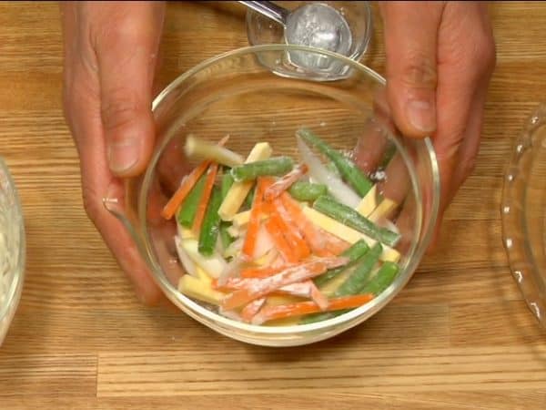 Place the vegetable strips into a bowl. Add a little tempura flour and toss to coat evenly.