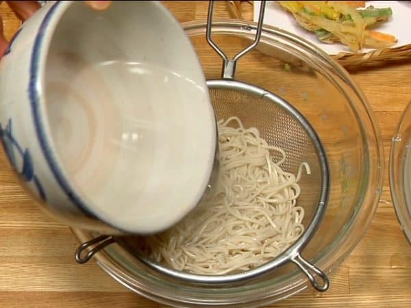 Pour hot water onto the soba noodles and warm them up. Drain the noodles again.