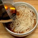 Transfer the noodles to the preheated bowl. Pour the hot noodle soup on the soba noodles.