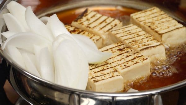 When the inside of the tofu begins to warm up, add the onion and simmer for 2 to 3 minutes.