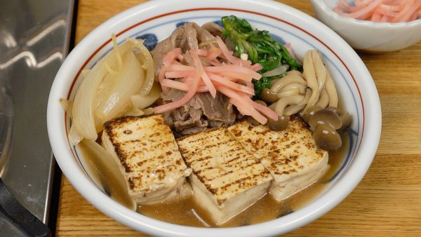 In a bowl, arrange the yaki dofu, beef, onion, shimeji and the shungiku. Ladle the broth over the Niku Dofu. Finally, garnish with the beni shoga, pickled ginger.