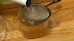 Realicemos el caldo para mezclar la masa para el bollo. Verter el líquido de camarón con un colador. Añadir el líquido de shiitake. Verter agua caliente para incrementar el volumen a 130 ml (0,55 partes de taza).
