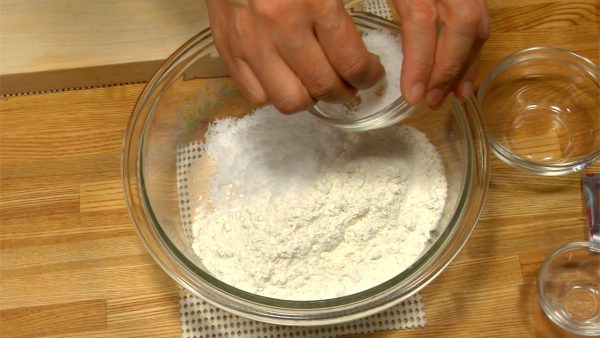 Let's make the dough for Nikuman. Add baking powder, instant yeast, sugar and salt to all-purpose flour. Lightly stir with a paddle.