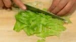 Удалите твердые части капусты и нарежьте их мелкими кусочками. Разрежьте часть листа на полоски по 2 см (0,8 дюйма) и нарежьте их на мелкие кусочки.