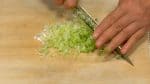 Зеленый лук разрезать пополам и мелко нарезать.