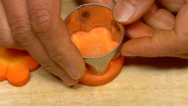 Coupez la carotte en rondelles de 7~8 mm (0.3 inch). Coupez les rondelles de carottes avec un emporte-pièce en forme de fleur de prunier.