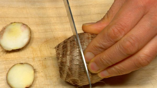 里芋はきれいに洗い上部と底を切り取ります。半分に切ります。