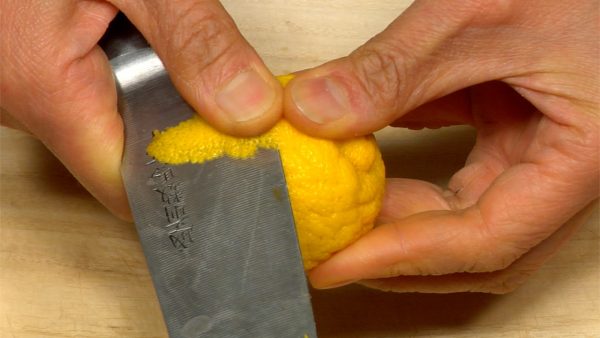 Shave a thin slice of yuzu peel and trim it into a rectangle.