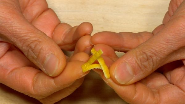 Make cuts in the yuzu peel in opposite directions. Twist each end of the yuzu peel and shape it into a triangle.