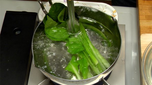 小松菜の下準備です。熱湯に塩を入れます。まず茎を入れ、葉も茹でます。