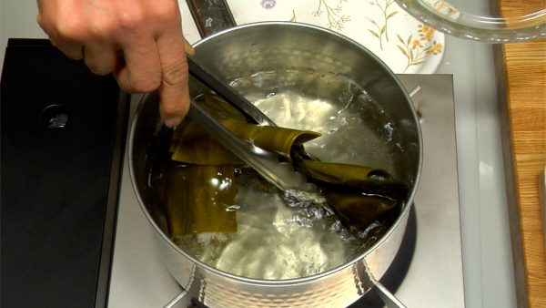 Let's make ozoni soup. Heat the kombu dashi stock over the stove. Remove the kombu seaweed just before it starts to boil.